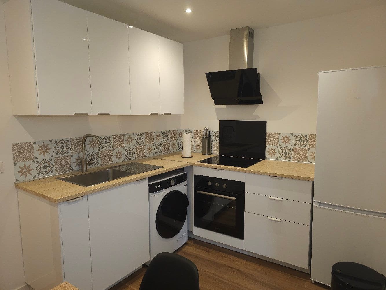 Cuisine rénovée en L avec façades blanches et crédence en carreaux de ciment, logement à Longjumeau